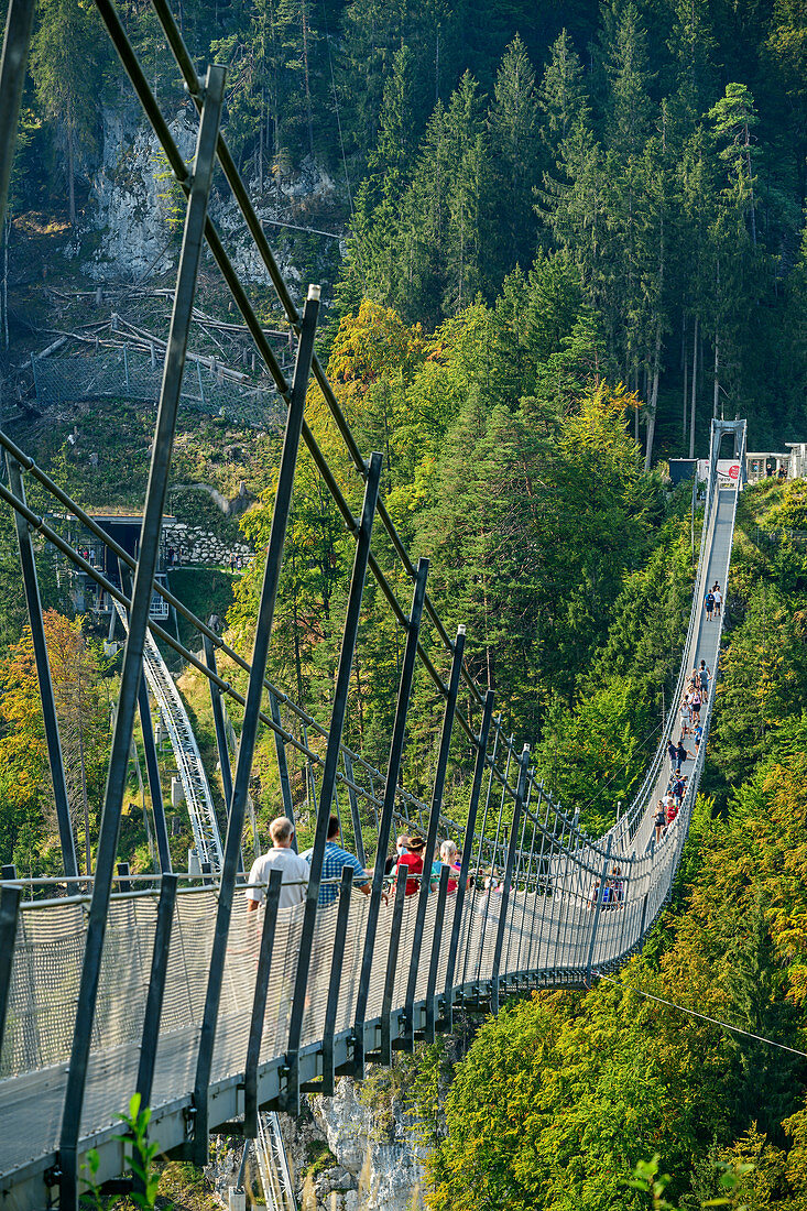 Mehrere Personen gehen über die Seilbrücke Highline 179, Ehrenberg, Reutte, Tirol, Österreich
