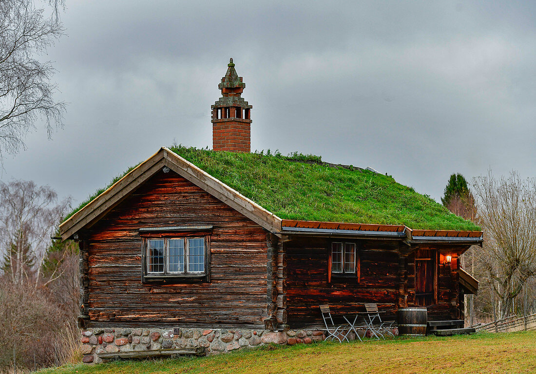 Eine Holzhütte in traditioneller Bauweise mit Grasdach, Tällberg, Dalarna, Schweden