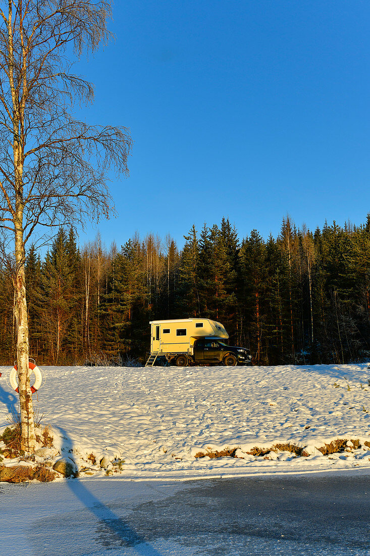 A motorhome on the snowy shore of a lake near Lycksele, Västerbottens Län, Sweden
