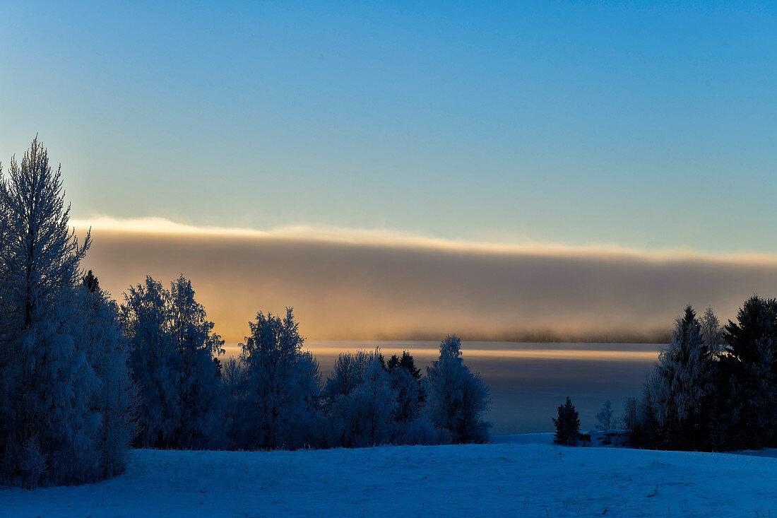 Wolkenwand über einem See im Winter in Lappland, bei Dorotea, Västerbottens Län, Schweden