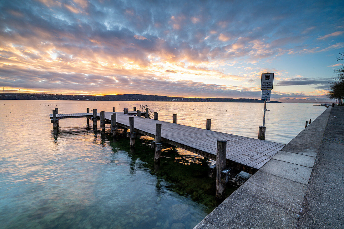 Sonnenaufgang an der Uferpromenade mit Badesteg am Nordufer des Starnberger Sees, Starnberg, Bayern, Deutschland.