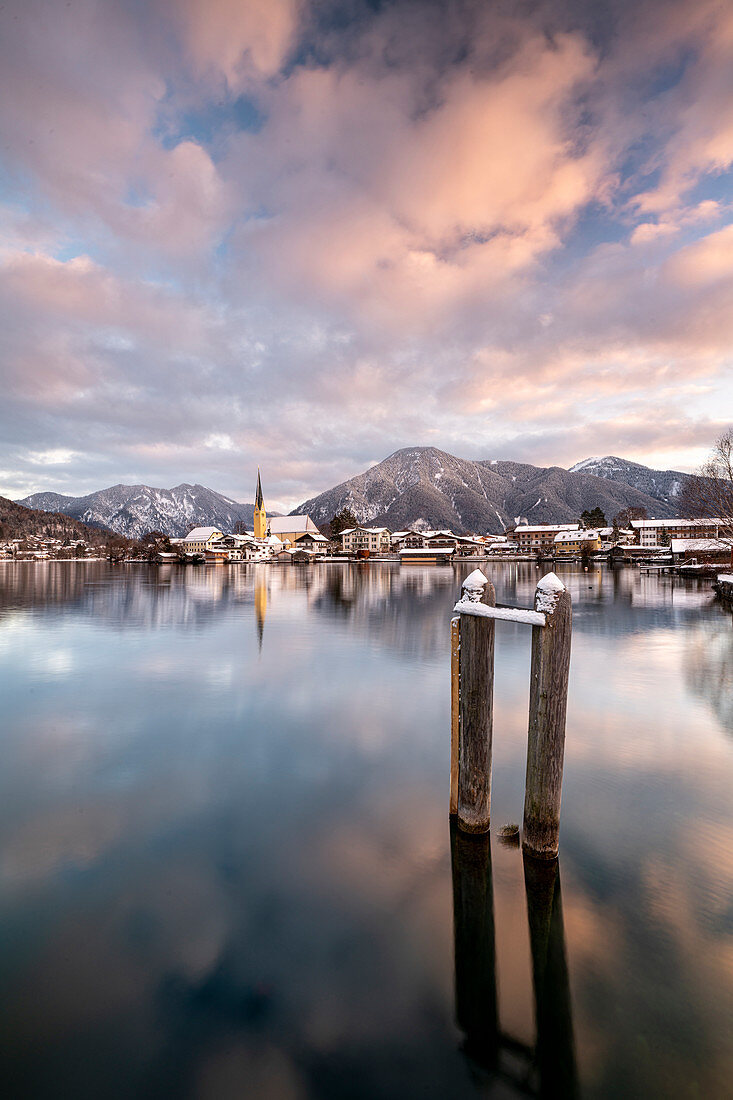 View over the wintry Tegernsee to the village of Rottach-Egern with the church Sankt Laurentius, Bavaria, Germany.