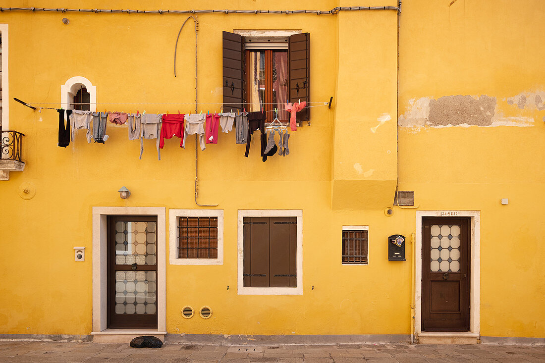 Blick auf eine gelbe Hausfassade mit Wäscheleine in Cannaregio, Venedig, Venetien, Italien, Europa