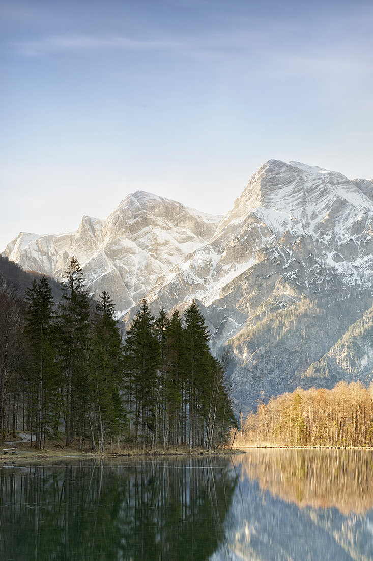 The Zehnerkogel, Elferkogel and Zwölferkogel on the Almsee shine in the rising sun.