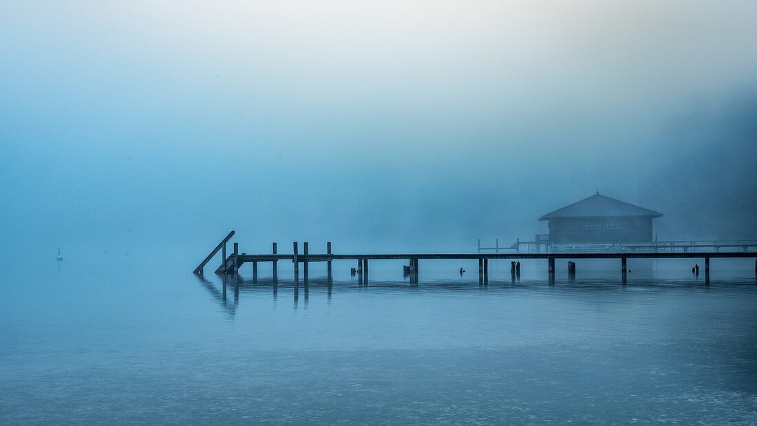 Boathouse with jetty in the fog on Lake Starnberg, Garatshausen, Bavaria, Germany