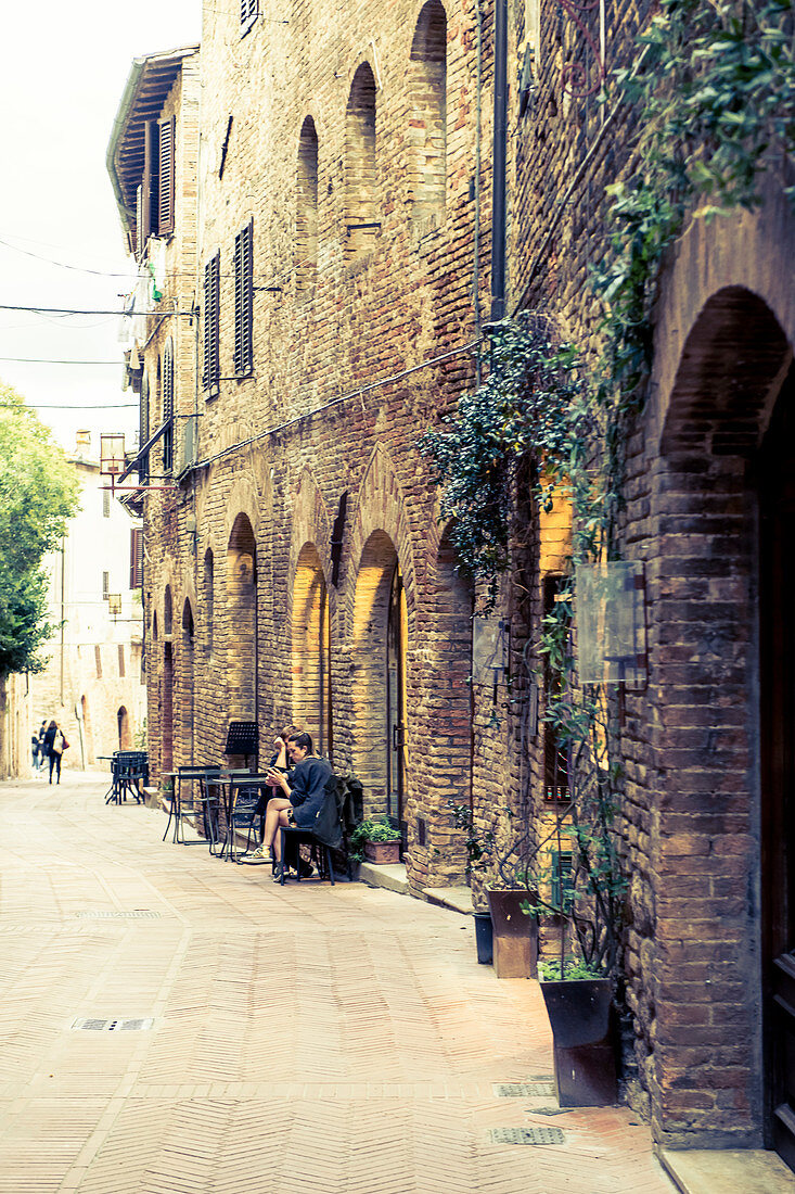 Straßencafe in den Gassen von San Gimignano, Provinz Siena, Toskana, Italien