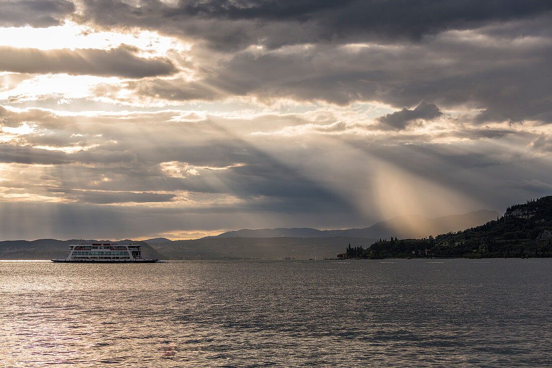 Ferry in dramatic lighting, Garda, Lake Garda, Province of Verona, Italy