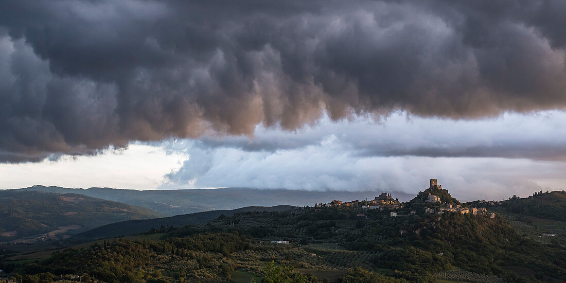 Dramatische Wolkenstimmung über einer Burg im Val d'Orcia, Toskana, Italien