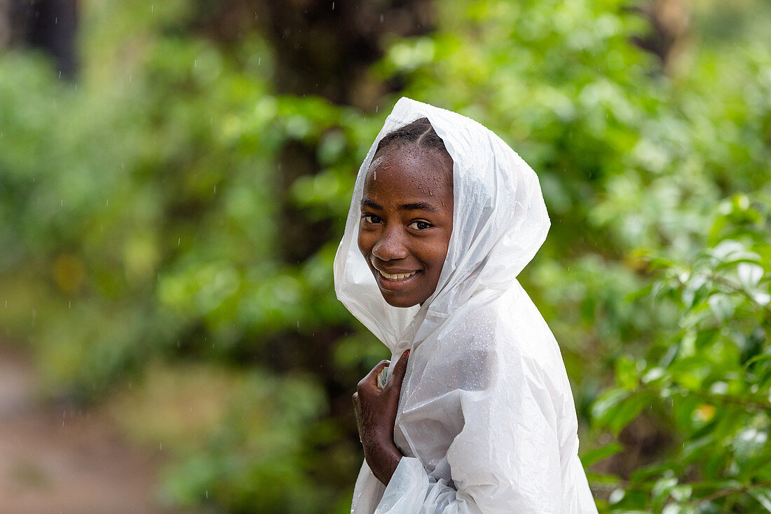 Junge Frau, Mädchen mit Regenumhang im Regen, südliches Madagaskar, Afrika