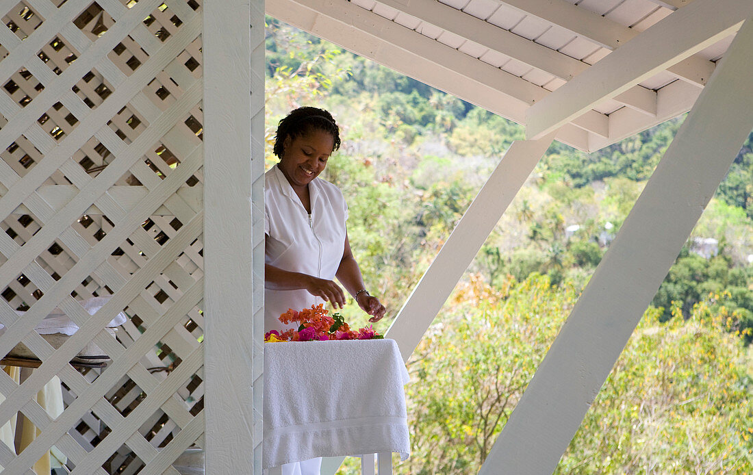 Spa-Therapeut bereitet Blumen in einer weißen Kabine vor. St. Lucia, Westindische Inseln.