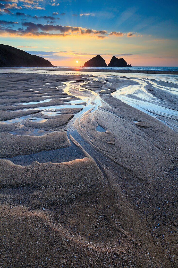 Sonnenuntergang im März vom Strand in Holywell Bay an der Nordküste von Cornwall eingefangen. Das Bild wurde sorgfältig zusammengestellt, um das Wasser am Strand optimal zu nutzen.