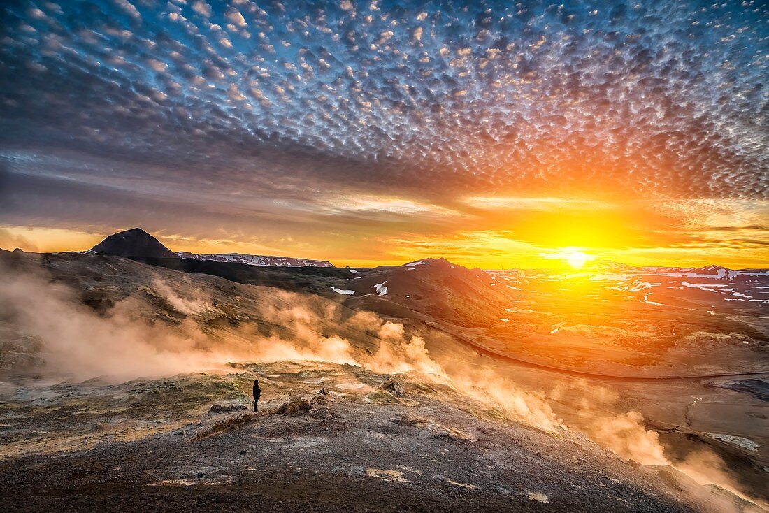 Woman standing by geothermal hot springs, mud pots and fumaroles, Namaskard close to Lake Myvatn, Northern, Iceland