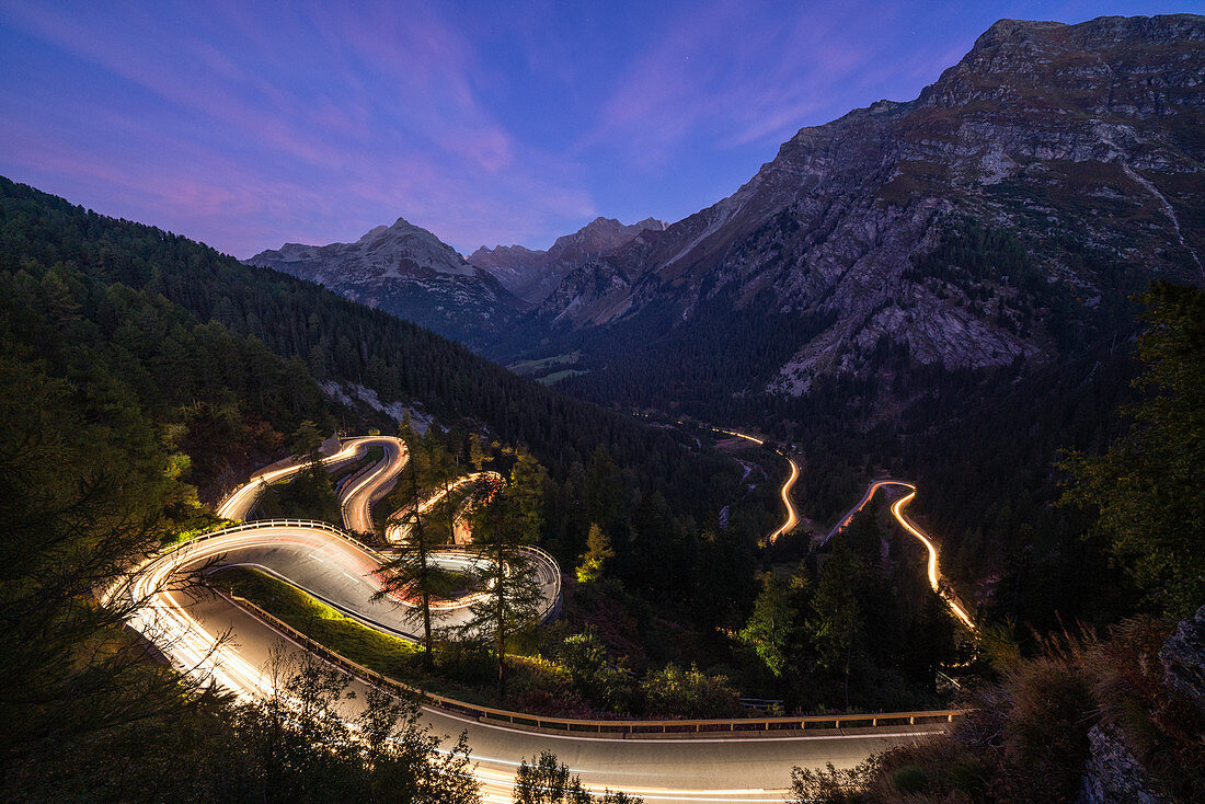 Car trails lights on narrow bends of Maloja Pass mountain road, Engadine, Canton of Graubunden, Switzerland, Europe