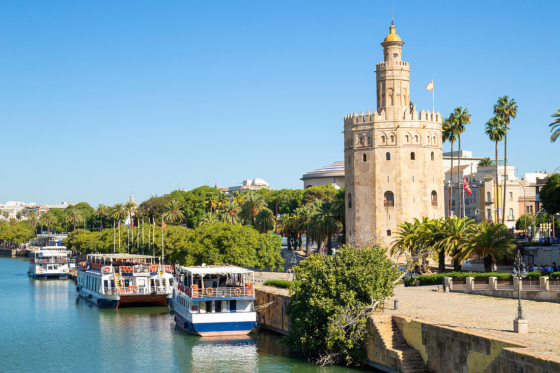 Ausflugsboote, die am Ufer des Flusses Guadalquivir nahe dem Torre del Oro, Paseo de Cristobal Colon, Sevilla, Andalusien, Spanien, Europa festgemacht sind
