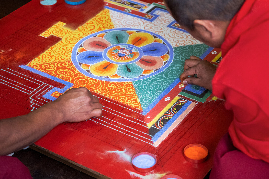 Buddhistische Mönche, die ein Diorama (Mandala) mit farbigem Sand herstellen, das einmal hergestellt wurde, werden abgewischt, um Vergänglichkeit und Vergänglichkeit zu demonstrieren, Bhutan, Asien