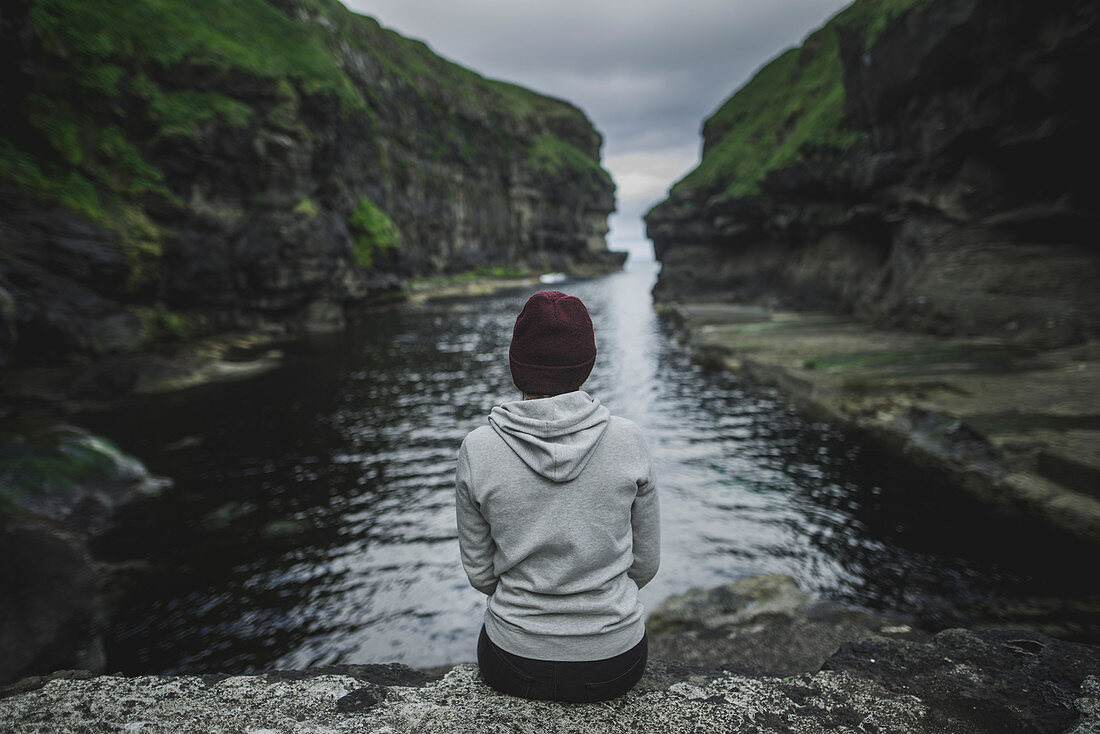 Denmark, Faroe Islands, Gjgv, Woman sitting in gorge