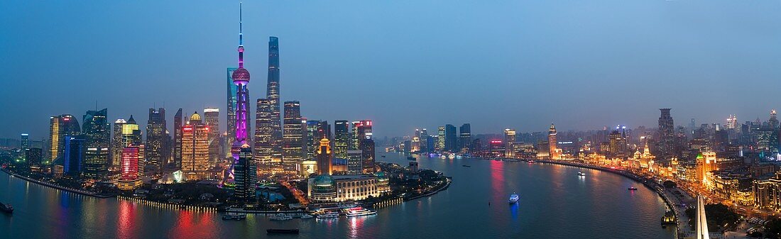Skyline des Pudong-Finanzviertels über Huangpu-Fluss in der Dämmerung, Shanghai, China