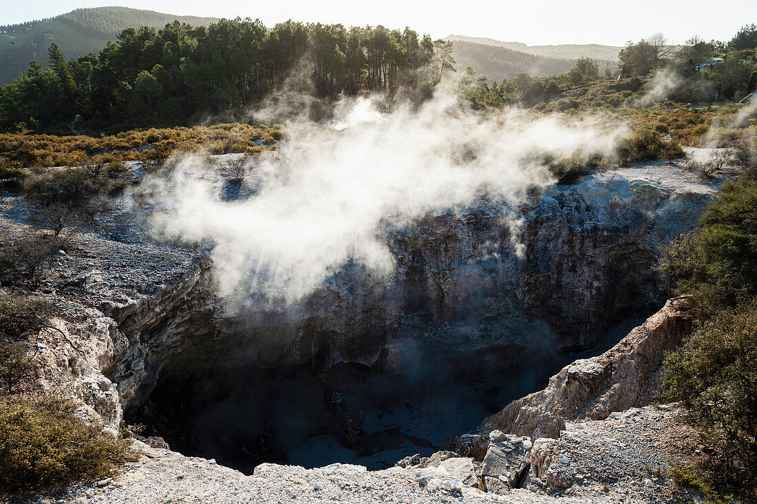 Blick in einen Krater mit geothermischem Wärmedampf, der aus dem Wasser aufsteigt