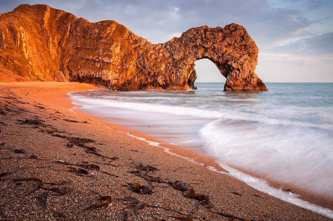 Der natürliche Seebogen an der Durdle Door an der Juraküste von Dorset, der Mitte April im späten Abendlicht gebadet wurde.