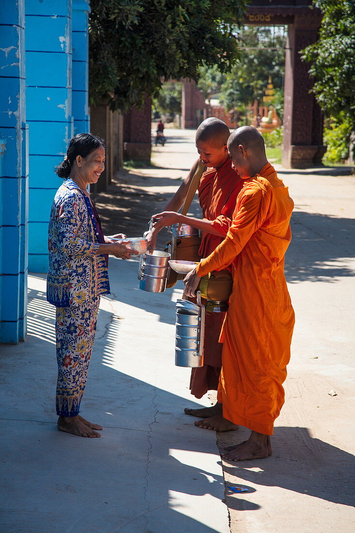 Frau offeriert buddhistischen Mönchen Essen als Almose, Oknha Tey Insel, Fluss Mekong, nahe Phnom Penh, Kambodscha, Asien