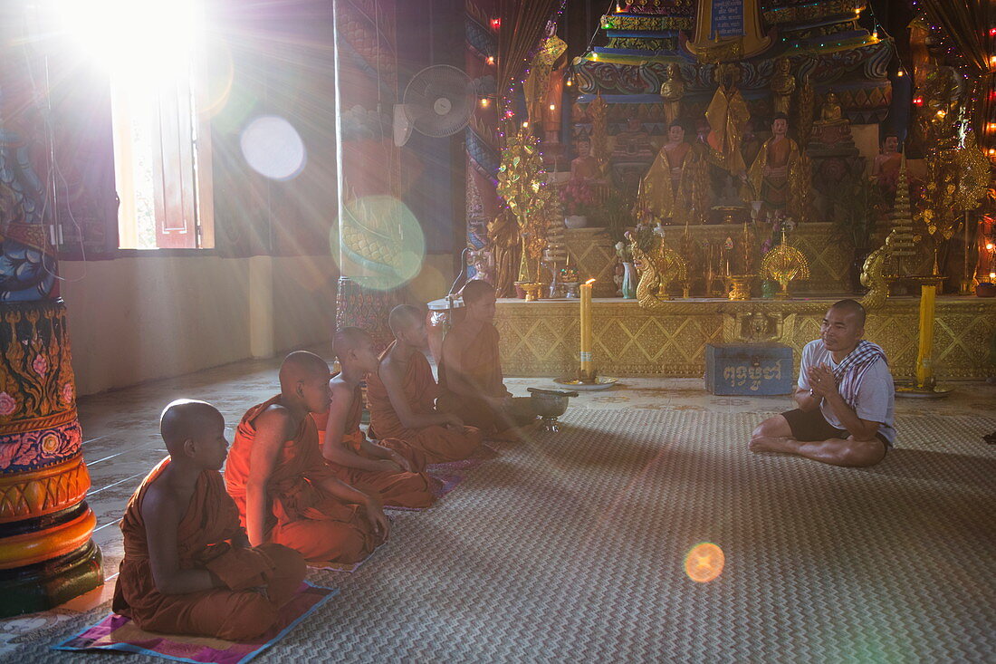 Guide von Flusskreuzfahrtschiff betet mit buddhistischen Mönchen im Tempel, Preah Prosop, Fluss Mekong, Kandal, Kambodscha, Asien