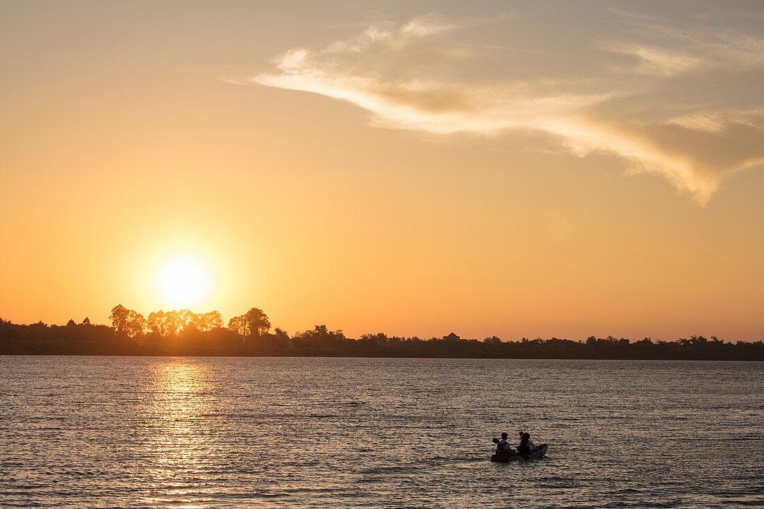 Silhouette of young couple during kayak excursion from river cruise ship on Mekong at sunset, near Preah Prosop, Mekong River, Kandal, Cambodia, Asia