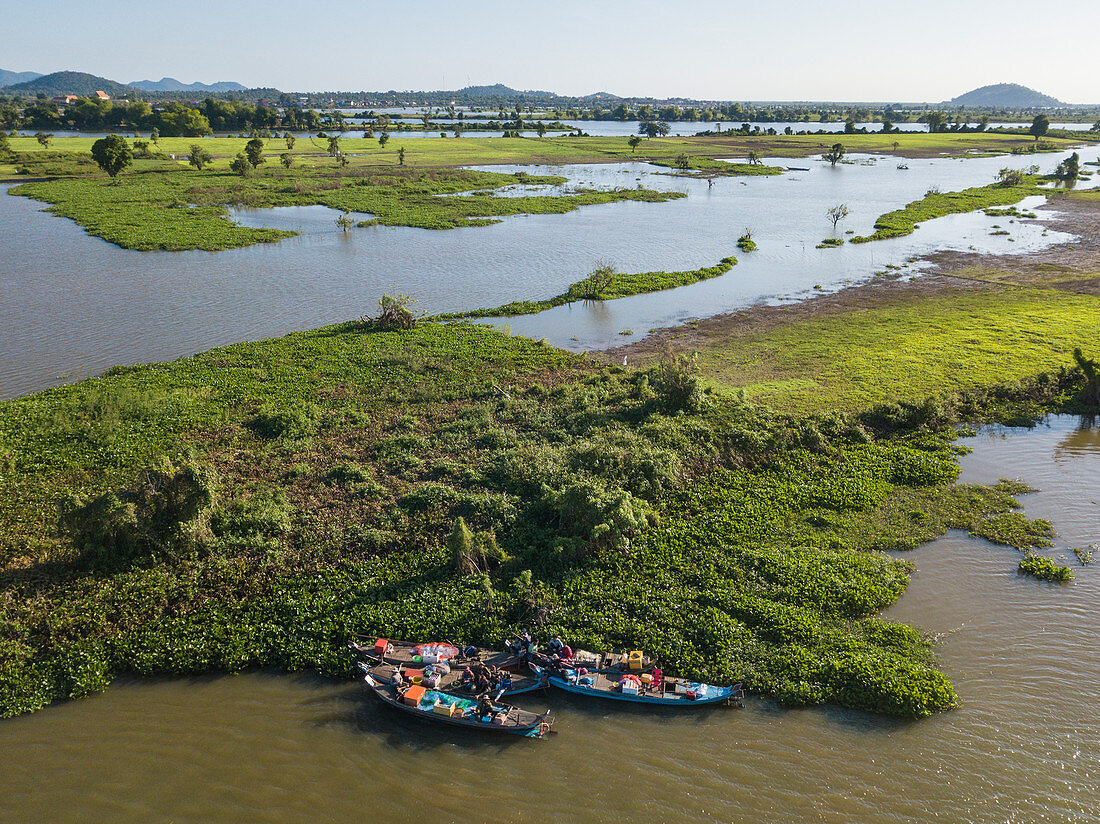 Luftaufnahme von Fischern auf einer Gruppe von Longtailbooten entlang dem Ufer von Fluss Tonle Sap mit überfluteten Reisfeldern dahinter, nahe Kampong Chhnang, Kampong Chhnang, Kambodscha, Asien