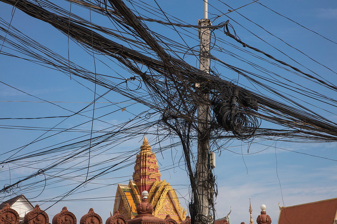 Eine chaotische und dennoch funktionierende Ansammlung an Strom- und Telefonleitungen in der Nähe vom Royal Palace Komplex, Phnom Penh, Kambodscha, Asien