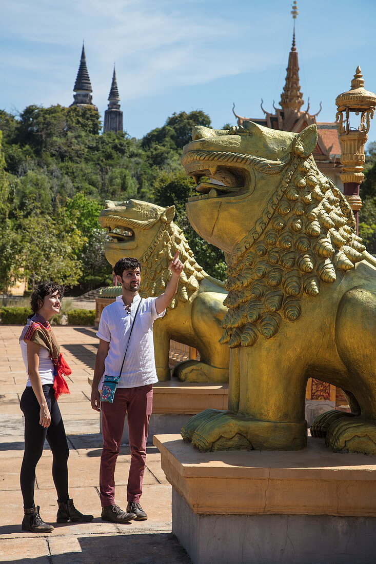 Junges Paar betrachtet Drachenskulpturen außerhalb des Prasat Nokor Vimean Sour Tempel, Oudong (Udong), Kampong Speu, Kambodscha, Asien
