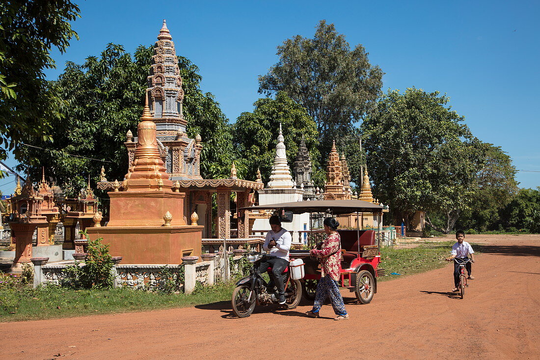 Moped rickshaw on dirt road in front of stupas, Kaoh Chen, Koh Chen Island, Kampong Cham, Cambodia, Asia