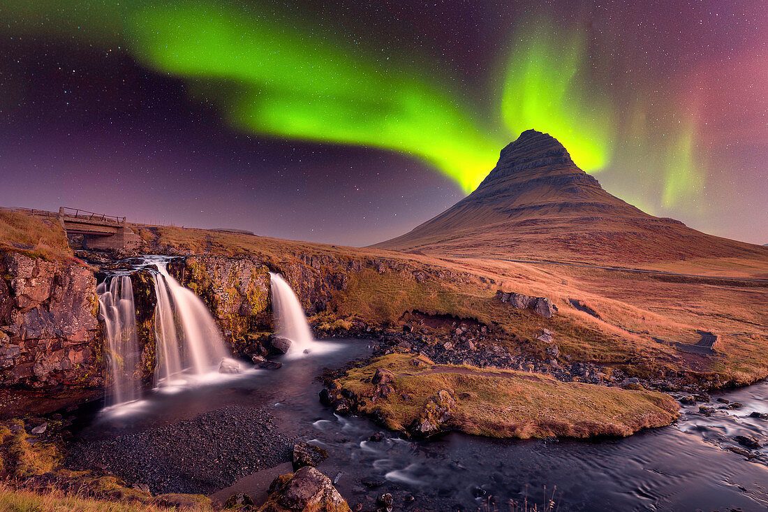 Aurora Borealis (Nordlichter) über Kirkjufell Mountian mit einem kleinen Wasserfall in Island, Polarregionen