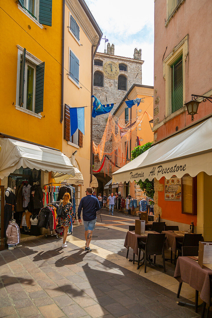 Ansicht von Cafés und Besuchern auf schmaler Straße an einem sonnigen Tag, Gardasee, Gardasee, Provinz Verona, Venetien, italienische Seen, Italien, Europa