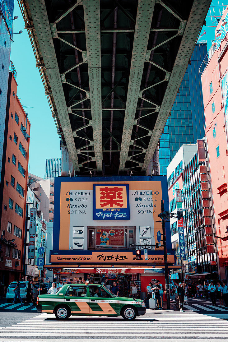 Taxi under a bridge in Akihabaras Hokuriku main street, Toyko, Japan