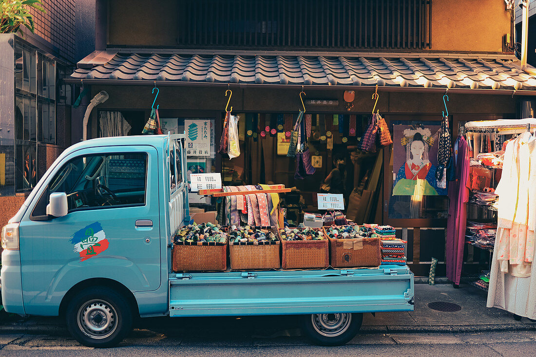 Shop front for textiles in Kyoto with a small delivery truck, Japan
