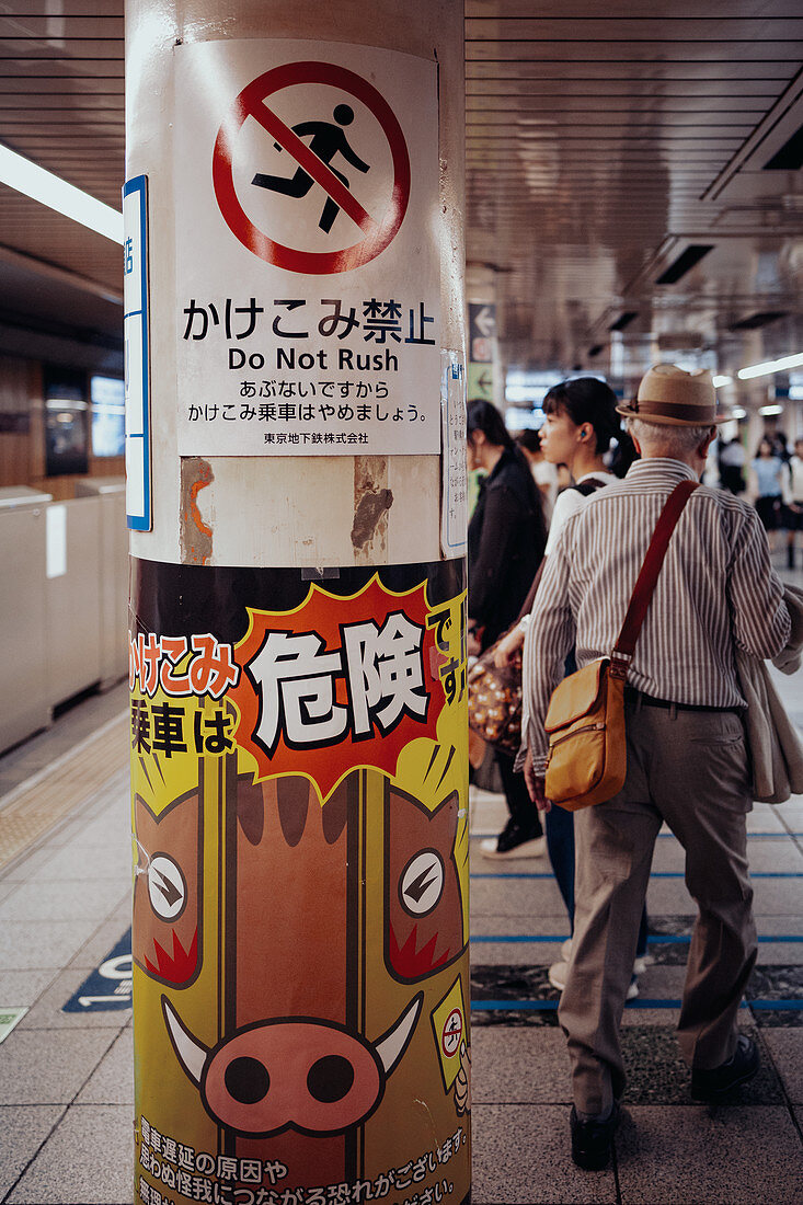 Rentner in der U-Bahn mit Warnhinweisen im Vordergrund, Tokio, Japan, Asien