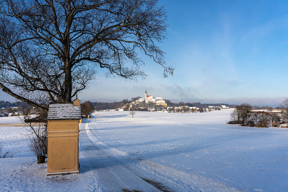 Andechs Monastery in a snowy winter landscape with a station path to the Friedrichskapelle, Andechs, Bavaria, Germany.
