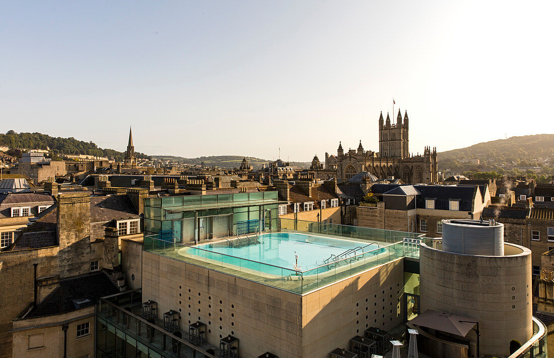 View of exterior roof-top pool set against the scenery of old turrets and buildgs, Horizontal. Bath. United Kingdom