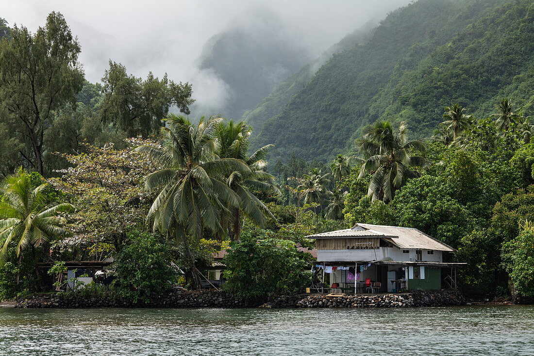 House on the edge of the lagoon with a mountain backdrop, Tahiti Iti, Tahiti, Windward Islands, French Polynesia, South Pacific