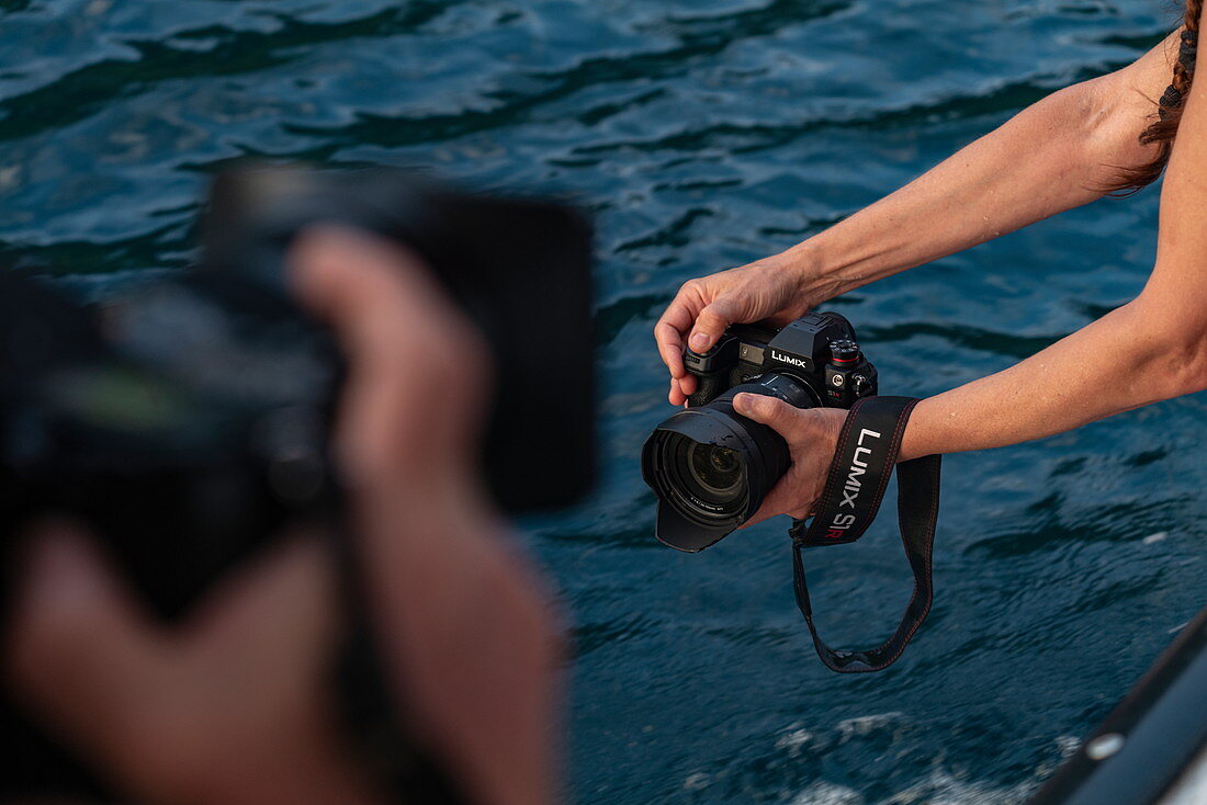 Panasonic Lumix S1R Kamera in Händen von Fotograf auf Ausflugsboot, Tahiti Iti, Tahiti, Windward Islands, Französisch-Polynesien, Südpazifik