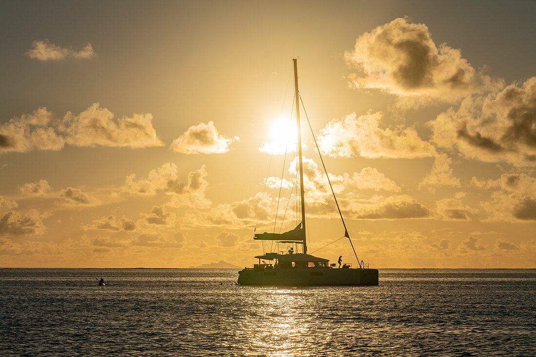 Silhouette von Katamaran Segelboot in der Lagune von Bora Bora bei Sonnenuntergang, Bora Bora, Leeward Islands, Französisch-Polynesien, Südpazifik