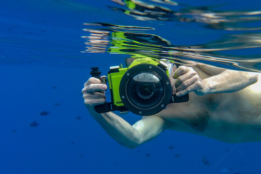 Unterwasseraufnahme von Mann mit Panasonic Lumix Kamera mit Unterwassergehäuse beim Schnorcheln in der Lagune von Bora Bora, Bora Bora, Leeward Islands, Französisch-Polynesien, Südpazifik