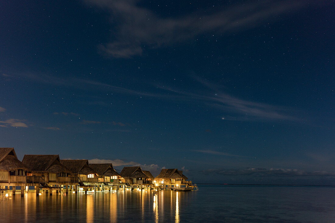 Überwasserbungalows des Sofitel Ia Ora Beach Resort in der Lagune von Moorea mit Kreuz des Südens im Sternenhimmel bei Nacht, Moorea, Windward Islands, Französisch-Polynesien, Südpazifik