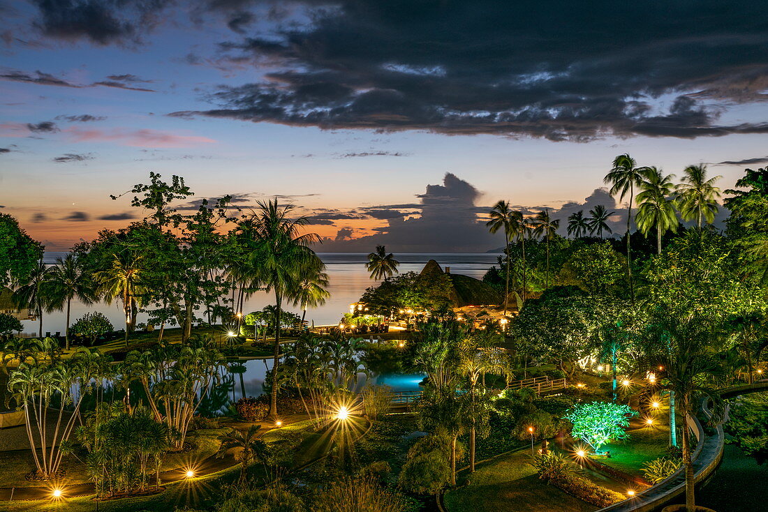 Palmen und Schwimmbad im Tahiti Ia Ora Beach Resort (managed by Sofitel) in der Abenddämmerung, nahe Papeete, Tahiti, Windward Islands, Französisch-Polynesien, Südpazifik