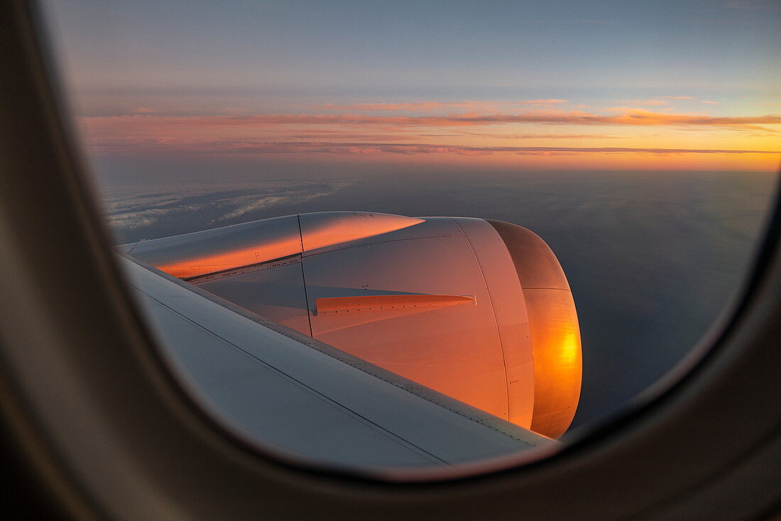 Blick durch Fenster auf Triebwerk von Air Tahiti Nui Boeing 787 Dreamliner Flugzeug bei Sonnenuntergang auf dem Flug vom internationalen Flughafen Los Angeles (LAX) in den USA zum internationalen Flughafen Tahiti Faa'a (PPT) in Französisch-Polynesien
