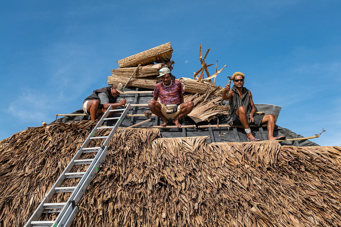 Workers repair roof of overwater bungalow at the Hilton Moorea Lagoon Resort & Spa, Moorea, Windward Islands, French Polynesia, South Pacific