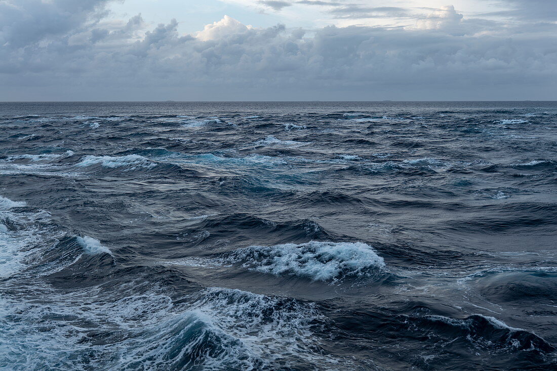 Wellen brechen am Riff neben der Garuae-Passage während das Passagierfrachtschiff Aranui 5 (Aranui Cruises) in das Atoll einfährt, Fakarava-Atoll, Tuamotu-Inseln, Französisch-Polynesien, Südpazifik