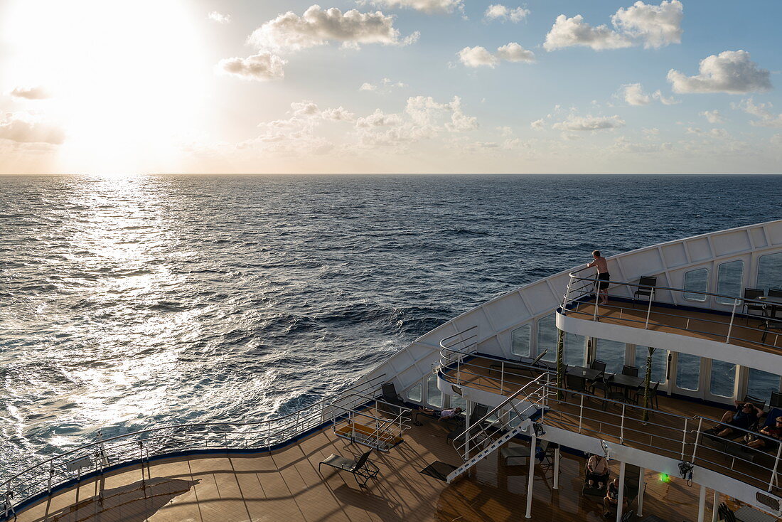 Hinteres Sonnendeck von Passagierfrachtschiff Aranui 5 (Aranui Cruises) bei Sonnenuntergang, auf See zwischen den Tuamotu-Inseln und den Marquesas-Inseln, Französisch-Polynesien, Südpazifik