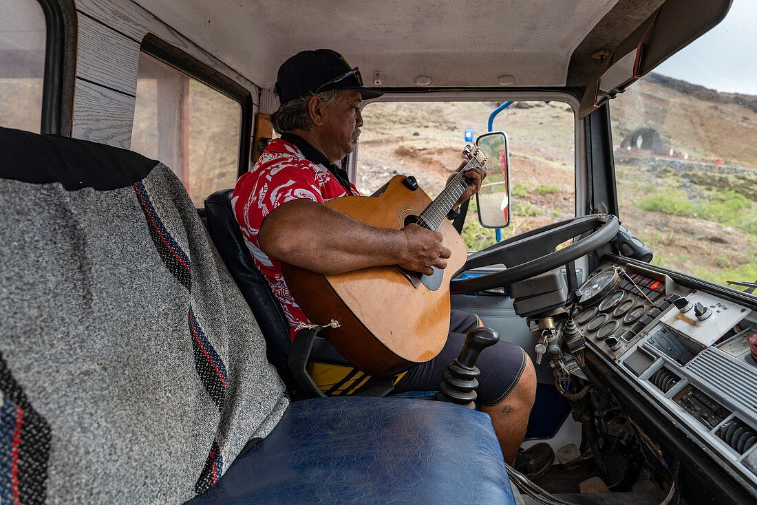 Busfahrer spielt Gitarre während er auf Passagiere einer Reisegruppe wartet, Tekoapa, Ua Huka, Marquesas-Inseln, Französisch-Polynesien, Südpazifik
