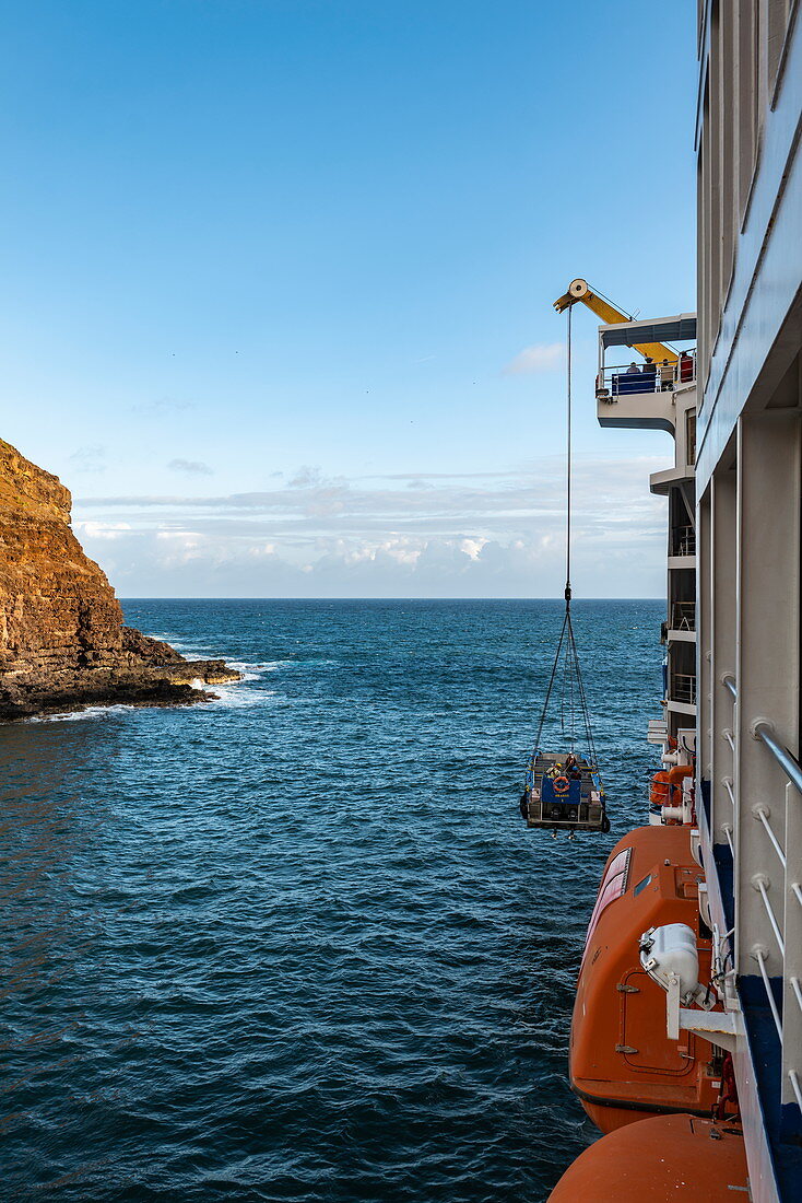 Dinghy is hoisted on board of passenger cargo ship Aranui 5 (Aranui Cruises), Anahehe, Vaipaee Bay, Ua Huka, Marquesas Islands, French Polynesia, South Pacific