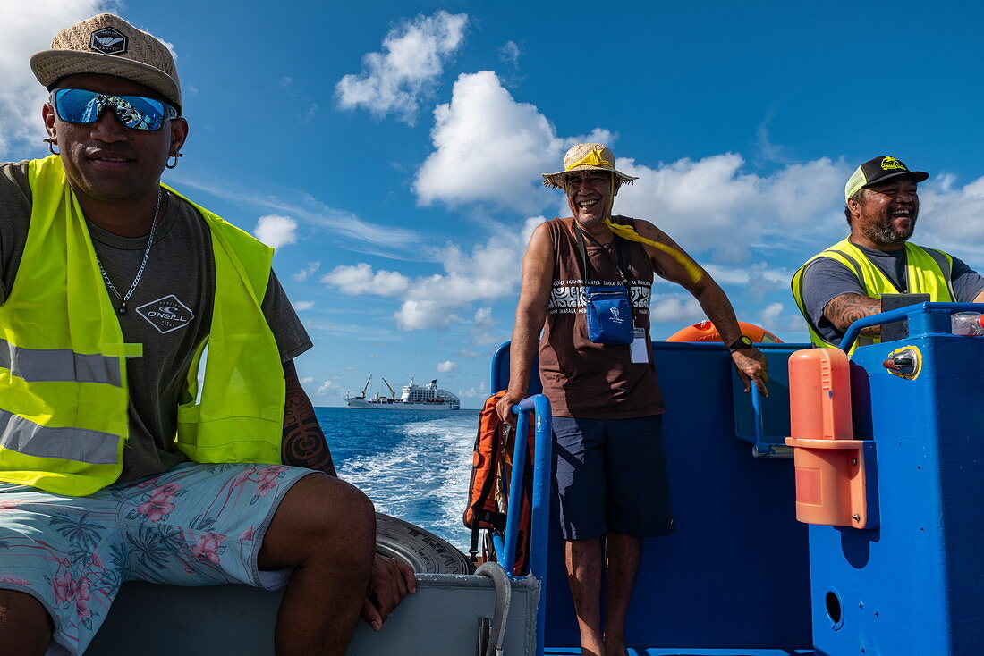 Fröhliche Matrosen steuern das Beiboot von Passagierfrachtschiff Aranui 5 (Aranui Cruises), Rangiroa Atoll, Tuamotu-Inseln, Französisch-Polynesien, Südpazifik